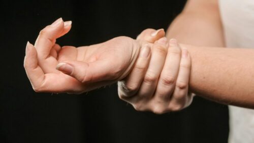 A close-up image of hands grasping a wrist, showcasing human connection and support.
